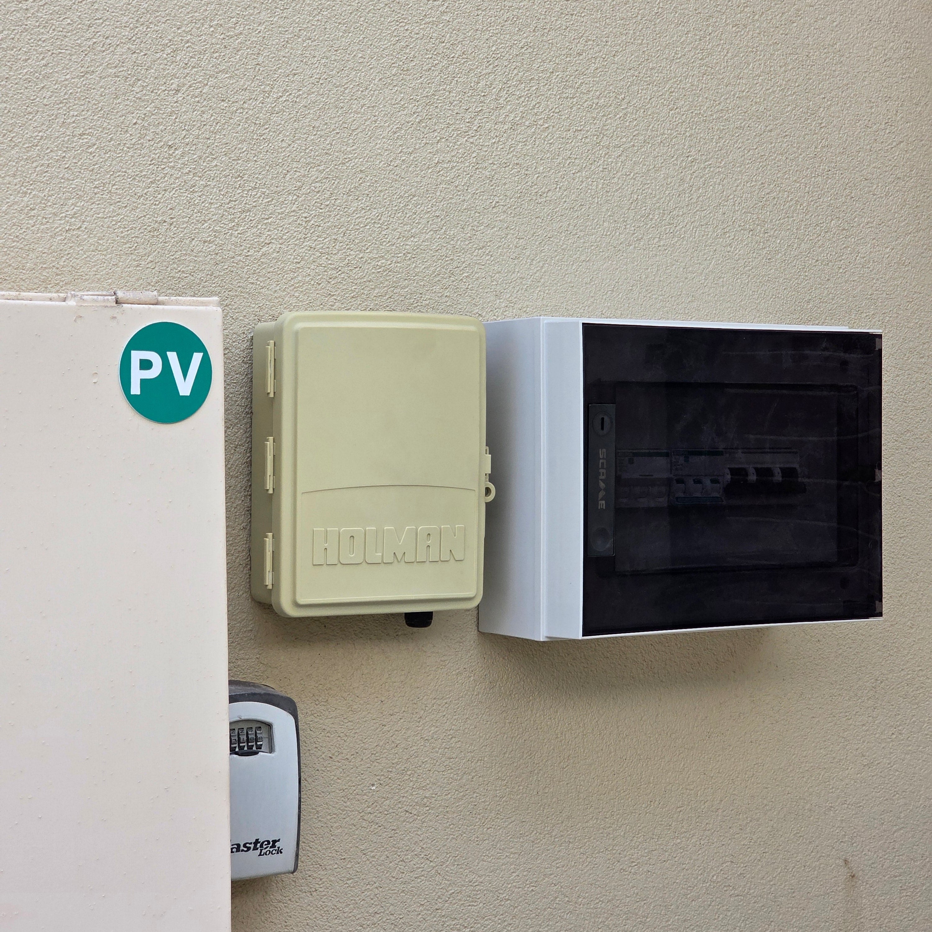Two electronic boxes on a beige surface with 'PV' label